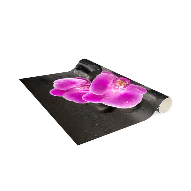 Teppich Blumen Pinke Orchideenblüten auf Steinen mit Tropfen