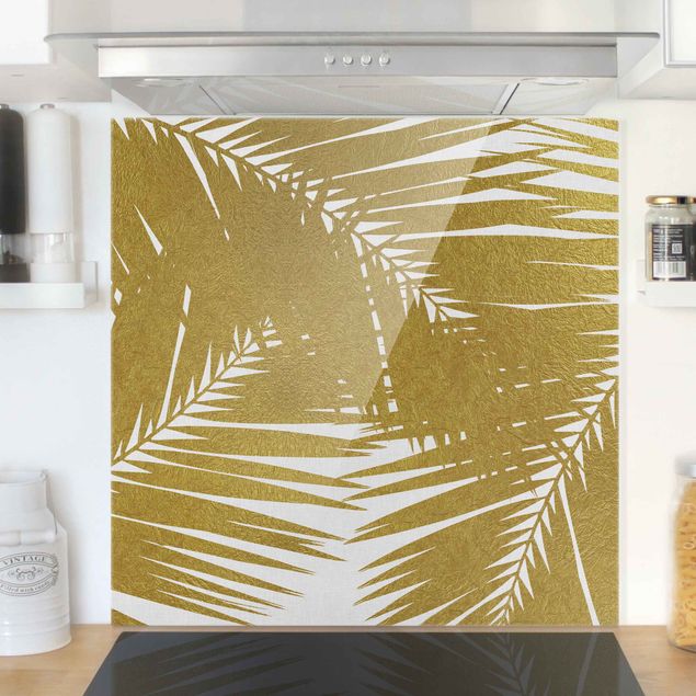 Glasrückwand Küche Blumen Blick durch goldene Palmenblätter
