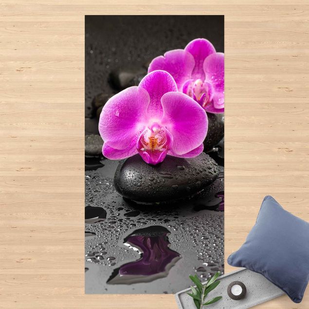 Vinyl-Teppich - Pinke Orchideenblüten auf Steinen mit Tropfen - Hochformat 1:2