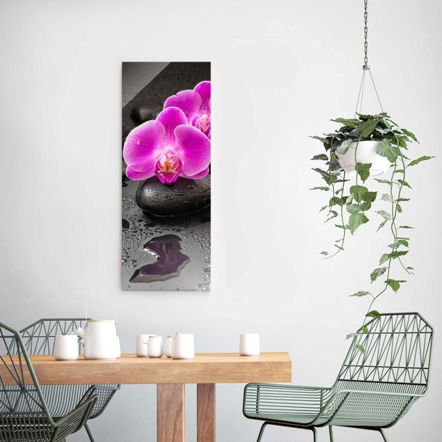Glasbild - Pinke Orchideenblüten auf Steinen mit Tropfen - Hochformat