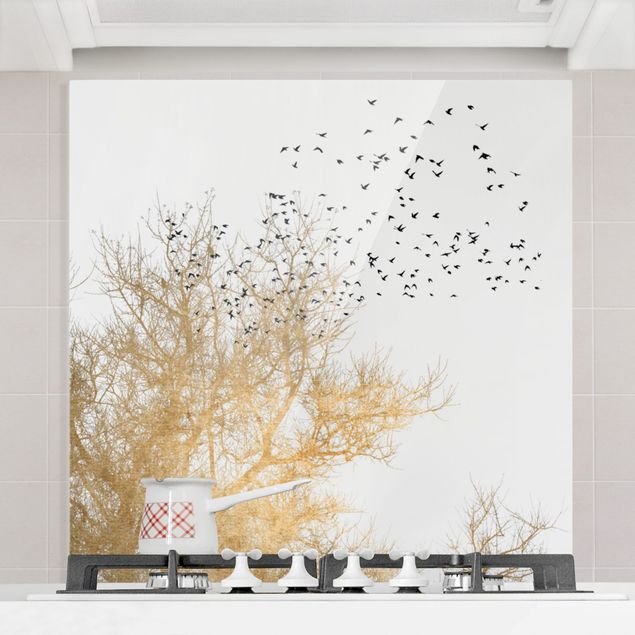 Glasrückwand Küche Wald Vogelschwarm vor goldenem Baum