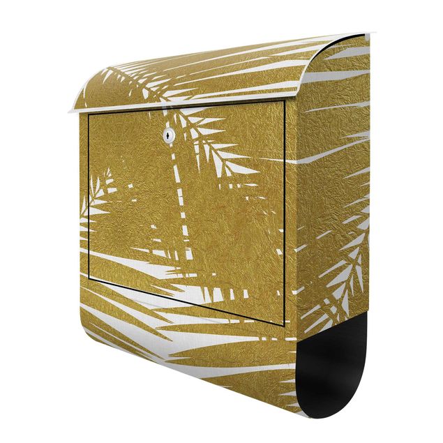 Briefkasten - Blick durch goldene Palmenblätter