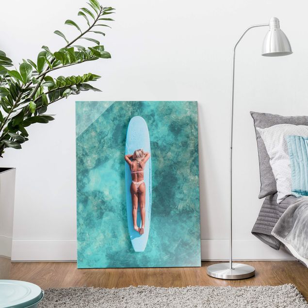 Glasbilder Strand und Meer Surfergirl auf Blauem Board