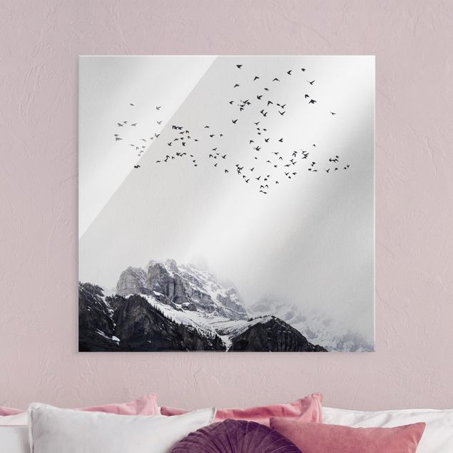 Glasbilder Natur Vogelschwarm vor Bergen Schwarz Weiß