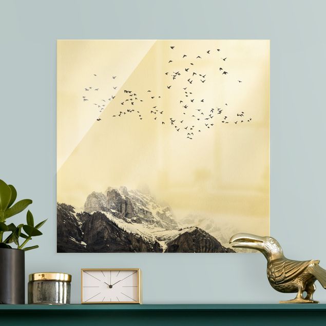 Glasbilder Natur Vogelschwarm vor Bergen Schwarz Weiß
